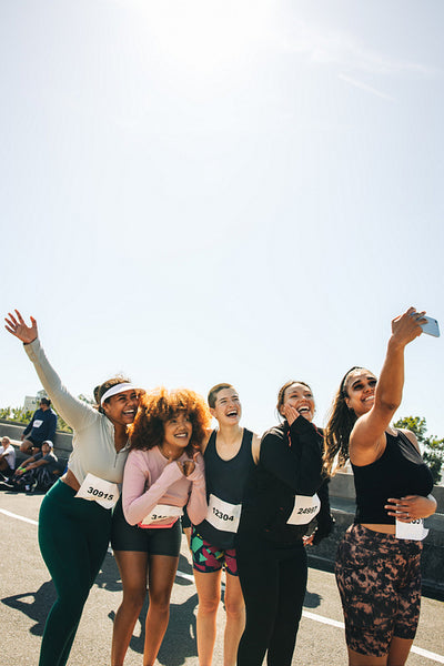 Group of friends posing for a selfie at a marathon event