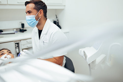Dentist treating patient in his clinic