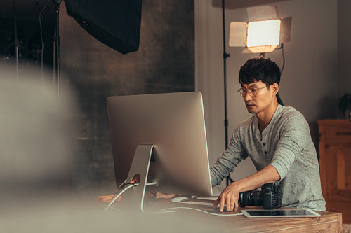 Photographer transferring photos on computer after shoot