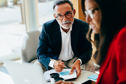 Senior management discussing details while planning in an office setting