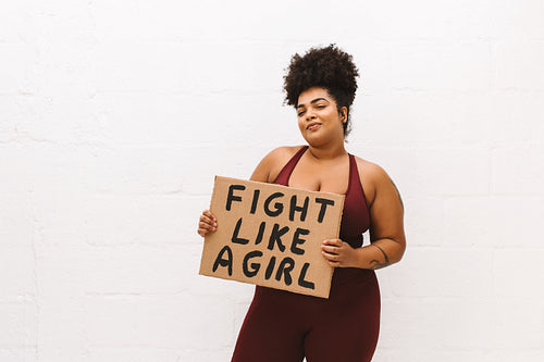Plus size woman with "Fight like a girl" placard