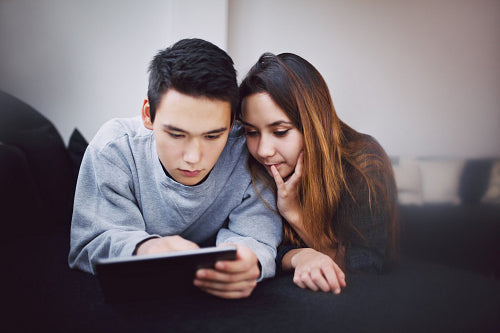 Teenage couple surfing internet on digital tablet