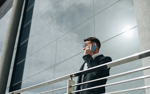 Businessman talking on mobile phone standing outdoors