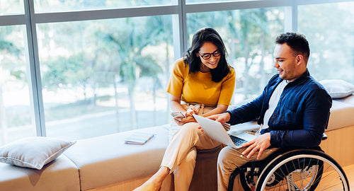 Business partners collaborate in wheelchair friendly office setting