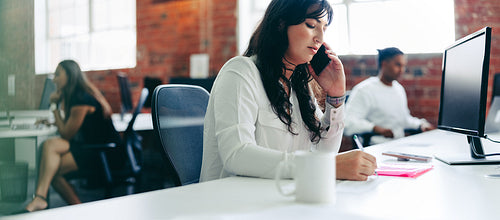 Focused businesswoman taking an important phone call in the offi