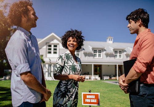 Happy young couple with real estate agent