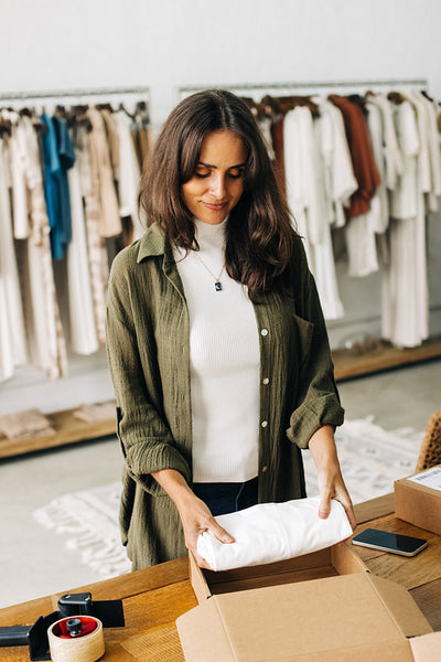 Business woman preparing packages for dropshipping in her boutique