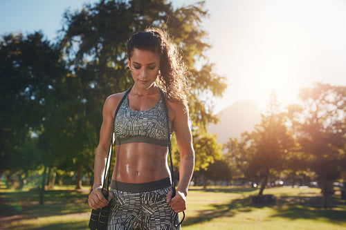 Fit and athletic woman in park with a jump rope