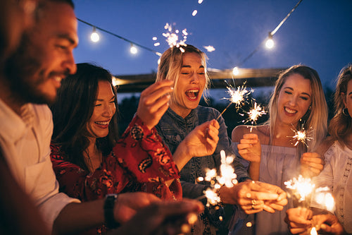 Group of friends with sparklers enjoying outdoor party