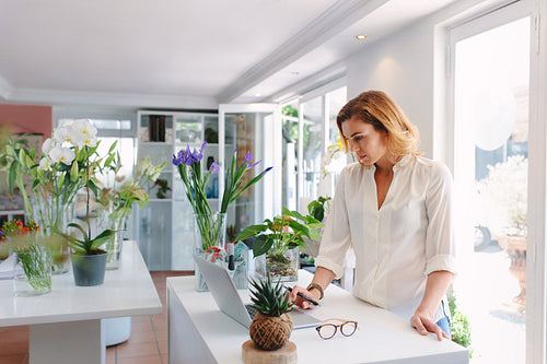 Flower shop owner working on laptop