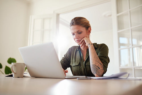 Woman working seriously on laptop at home