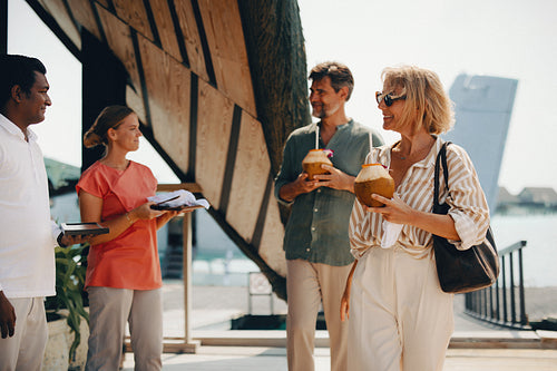 Group of adults arriving at a resort with refreshing drinks in hand