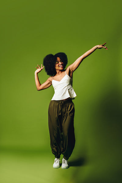 In a vibrant studio, a woman is dancing with joyful movement and freedom