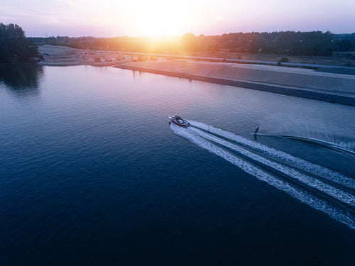 Man water skiing on lake behind boat