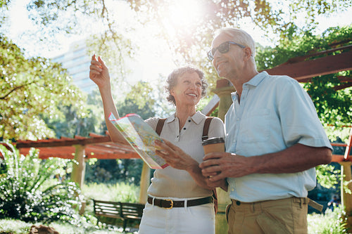 Happy senior tourists reading a map