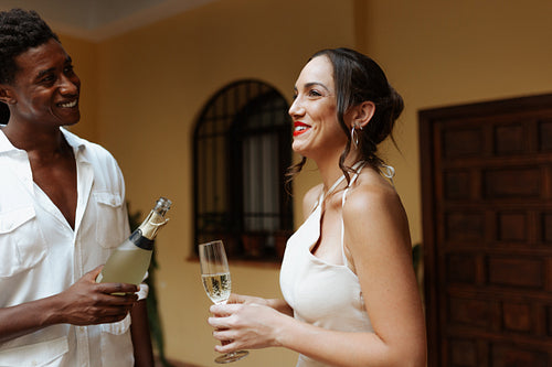 Cheerful couple pouring sparkling wine into a glass