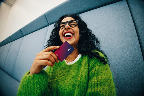 Student woman holding credit card for online payment and personal finance indoors