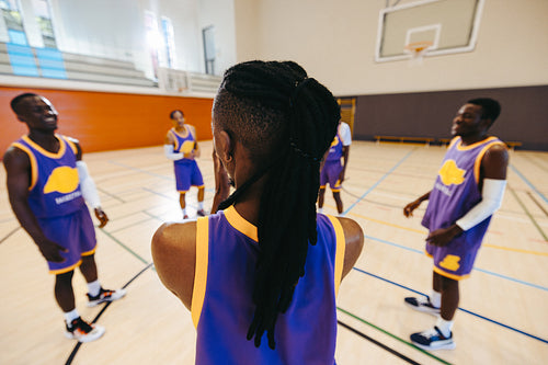 Basketball team members preparing during practice at an indoor court setting