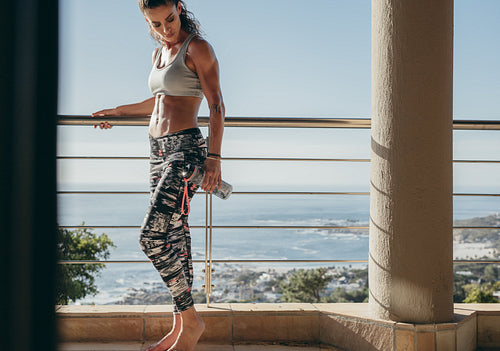 Muscular female in balcony with water bottle