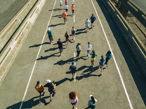 Group of diverse runners jogging on a sunny day outdoors