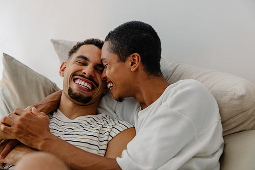 Happy couple embracing with smiles while relaxing together in a cozy setting