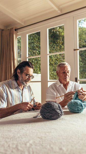 Senior friends knitting at home