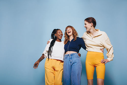 Three best friends laughing together in a studio