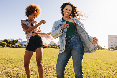 Generation Z women learning a dance routine in the park