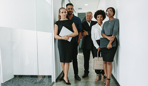 Multi-ethnic group of business people in office corridor