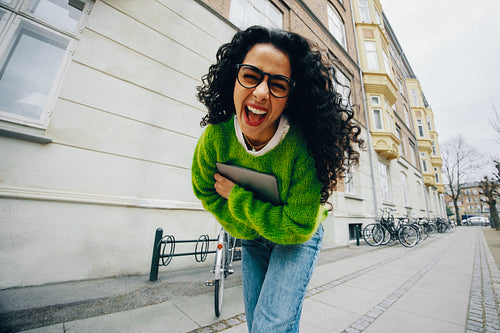 Tablet in hand, the woman walks through the city street for commuting