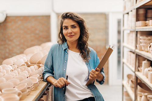 Confident businesswoman looking at the camera in her ceramic store