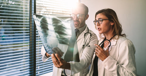 Doctors diagnosing patient illness using x-ray