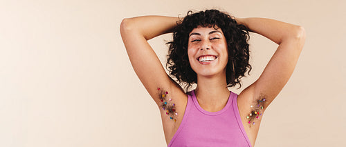 Happy young woman flaunting her decorated underarm hair