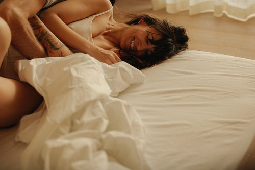 Intimate couple laughing together in bed