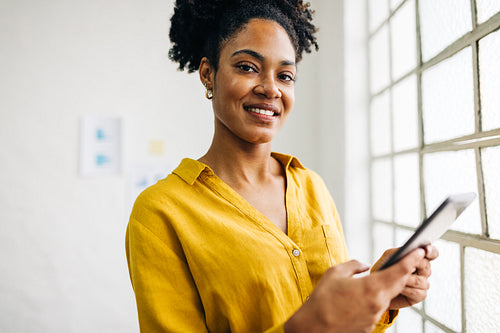 Woman with an fro using a tablet in a business office