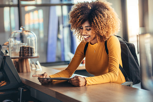 Smiling afro american woman ordering food standing at the billing counter