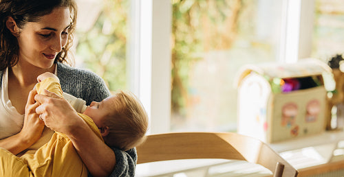 Loving mother feeding her child with baby bottle