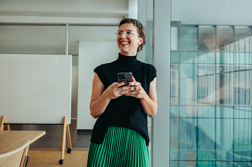 Confident non-binary entrepreneur in a modern office setting, exemplifying startup success and innovation