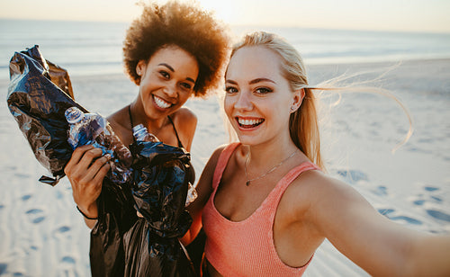 Women taking selfie after beach cleaning