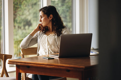 Woman at home lost in thought