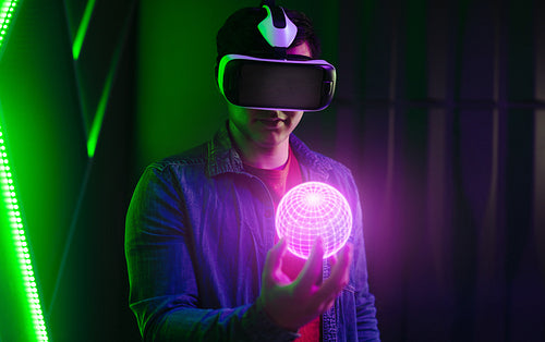 Young man wearing a VR headset and holding a virtual object