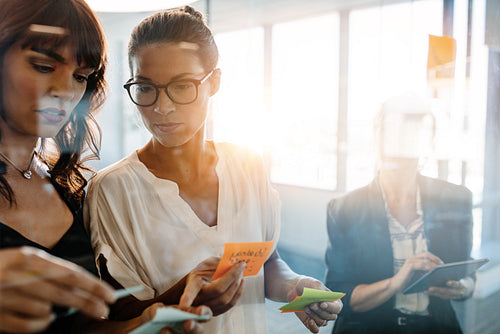 Professionals using adhesive notes for brainstorming