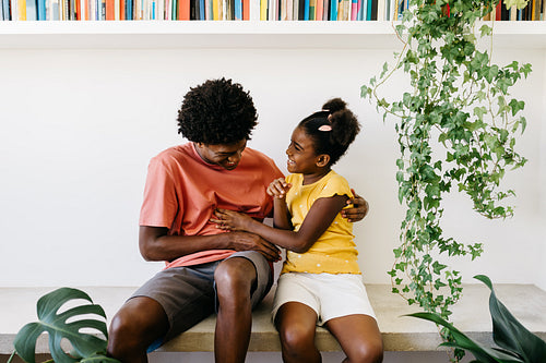 Happy black siblings being playful and having fun together at home