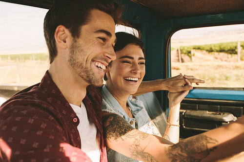 Young couple on a road trip driving in car