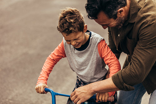 Kid having fun learning to ride bicycle