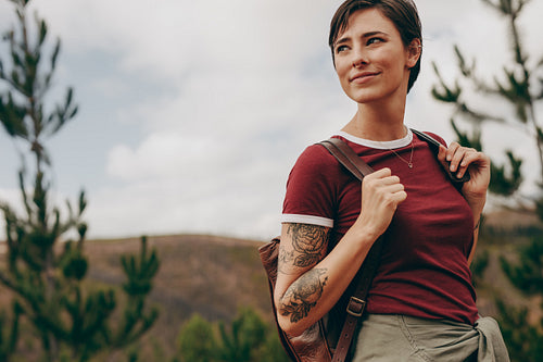 Woman hiker carrying a backpack looking away