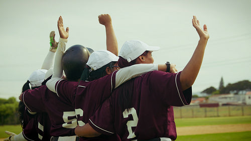 Baseball team celebrates victory with arms raised in triumph