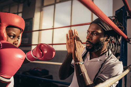 Kid wearing boxing gloves and head guard practicing punches