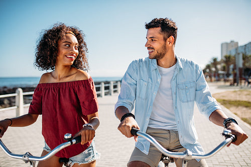 Romantic couple riding bicycles in street