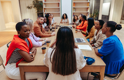 Creative agency team meeting around a conference table discussing strategies and ideas